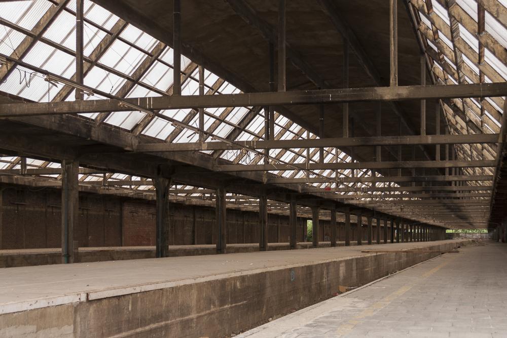 zicht op de verlaten perrons van Gare De Montzen,
              een groot vervallen station dat een bekende urbex locatie is geworden